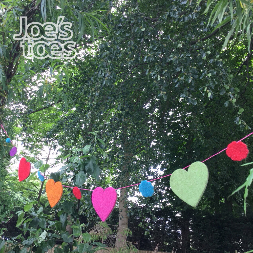 Joe's Toes felt garland showing completed bunting using 1.5m cord, felt flowers and large felt hearts with two pompoms